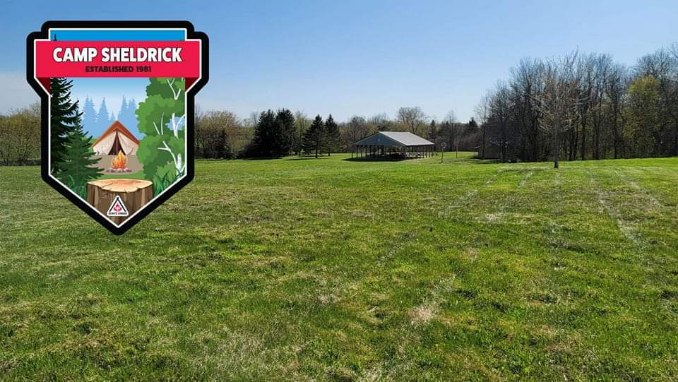 Photo taken from the Council fiepit, located two-thirds of teh way up the hill, and looking back down towards the pavillion. The camp crest is located in the upper left side of the image.