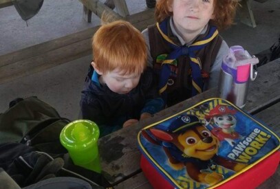 A group of youth sitting at a tanle in the pavillion, working on a craft
